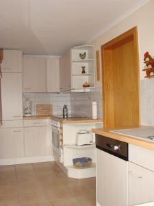 eine Küche mit weißen Schränken und einem weißen Gerät in der Unterkunft Ferienhaus "Antje" in Bad Zwischenahn
