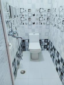 a bathroom with a toilet and black and white tiles at RK appartment 3 bedroom with kitchen and balcony in Varanasi