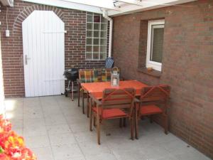 eine Terrasse mit einem Tisch und Stühlen an einer Ziegelwand in der Unterkunft Ferienhaus "Antje" in Bad Zwischenahn