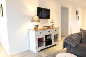 a living room with a tv on top of a white cabinet at Appartement Geestblick in Garding