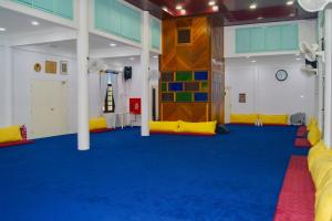 a large room with a blue carpet and a climbing wall at Astana Az-Zahrah in Bahau