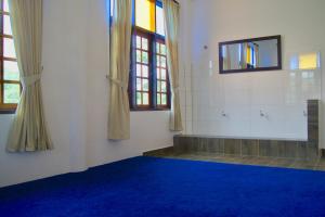 an empty room with a blue carpet and windows at Astana Az-Zahrah in Bahau +31 photos