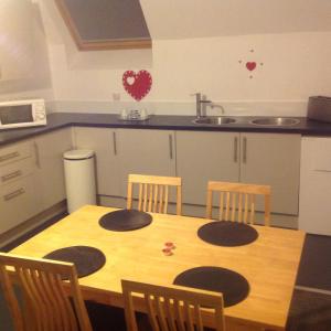 a kitchen with a wooden table with four chairs at WESTEND PROPERTY in Aberdeen