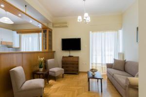 uma sala de estar com um sofá e uma televisão em Classy 2 bedroom apartment near Acropolis & Metro em Atenas