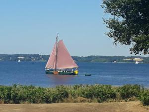 un velero en medio del agua en Ferienwohnung Leuchtturm 21, en Schausende