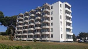 ein weißes Gebäude mit Balkonen an der Seite in der Unterkunft Ferienwohnung Leuchtturm 21 in Schausende