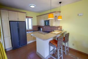 cocina con nevera azul y 2 taburetes en Apartment Delfin at Windsock Beach, en Kralendijk