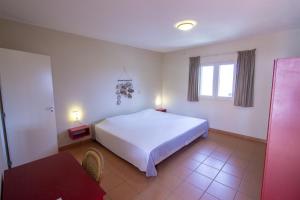 a bedroom with a large white bed and a table at Apartment Delfin at Windsock Beach in Kralendijk