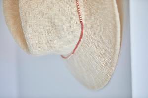 a hat with a red string hanging on a wall at Gavimar Ariel Chico Hotel and Apartments in Cala d´Or