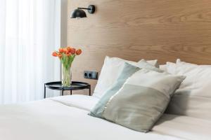 um vaso de tulipas laranja sentado em cima de uma cama em Central C&P Minimal Apartment em Tessalônica