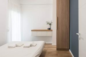 a bedroom with a bed with two towels on it at Central C&P Minimal Apartment in Thessaloniki +5 photos