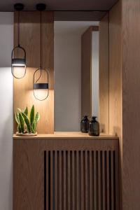 a room with a mirror and a radiator and two lights at Central C&P Minimal Apartment in Thessaloniki