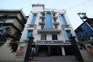 a tall white building with blue windows at Hotel Priya Palace in Guwahati