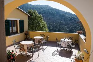 a patio with tables and chairs on a balcony at Agriturismo A Cà Vegia in Calice Ligure