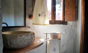 a bathroom with a large stone sink and a window at Essenza Sardegna in Torpè