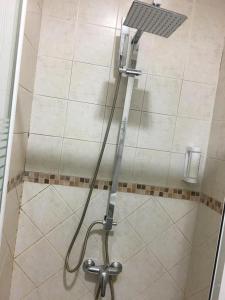 y baño con ducha con cabezal de ducha. en Hotel Nacional Melilla, en Melilla