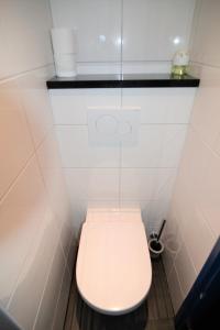 a white toilet in a bathroom with a white wall at Hotel Bienvenue in Rotterdam