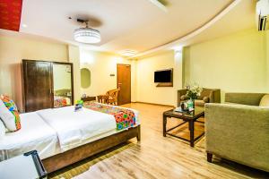 a hotel room with a bed and a couch at FabHotel Prince Park Vellore in Vellore