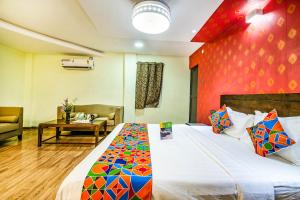 a bedroom with a bed with a red wall at FabHotel Prince Park Vellore in Vellore