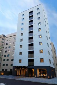 a tall white building with windows at Floral Hotel &middot; SakaisuJi-Honmachi Osaka in Osaka