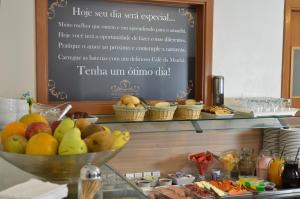 a buffet with a bowl of fruit on a table at Pousada Stillo Gramado in Gramado