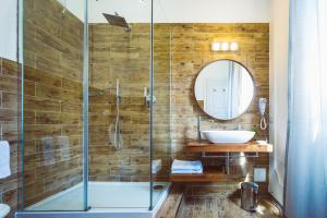 uma casa de banho com um chuveiro, um lavatório e um espelho. em Bluemoon Sardinia em Cagliari