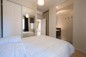 ein Schlafzimmer mit einem weißen Bett und einem Spiegel in der Unterkunft F3 Plein centre plage à 50 m (rue calme) parking possible in Saint-Raphaël