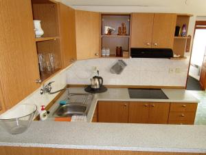 a kitchen with wooden cabinets and a sink at Holiday House Smetánek in Bruntál