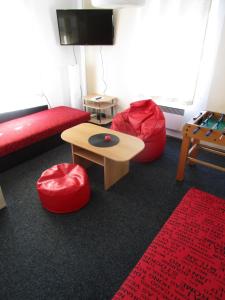 a living room with a red couch and a table at Holiday House Smetánek in Bruntál