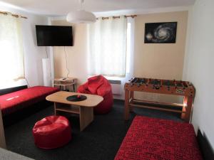 a living room with a red couch and a table at Holiday House Smetánek in Bruntál