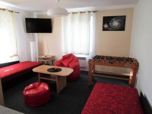 sala de estar con sofá rojo y mesa en Holiday House Smetánek, en Bruntál