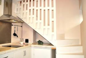 une cuisine avec des placards blancs et un escalier dans l'établissement Casa Braancamp II - Chic & Sweet, à Porto