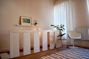- un lit bébé blanc dans une chambre avec fenêtre dans l'établissement Casa Braancamp II - Chic & Sweet, à Porto