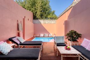 einen Hinterhof mit einem Pool und einer Terrasse mit Stühlen in der Unterkunft Casa da Praça in Porto