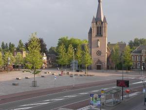 una calle con una iglesia con una torre de reloj en Hotel de Markt, en Valkenswaard