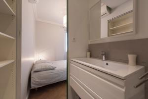 ein Badezimmer mit einem Waschbecken und ein Schlafzimmer mit einem Bett in der Unterkunft F3 Plein centre plage à 50 m (rue calme) parking possible in Saint-Raphaël + 20 Fotos
