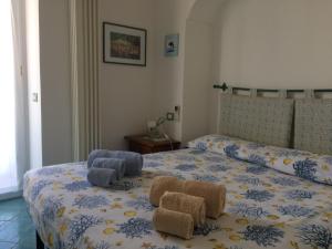 a bedroom with a bed with two towels and two chairs at LA CASETTA DI ERIKA in Lacco Ameno
