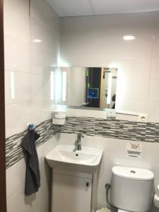 a bathroom with a sink and a toilet and a mirror at CASA SUR APARCAMIENTO GRATIS in Córdoba