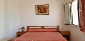 - une chambre avec un lit doté d'un couvre-lit rouge et d'une fenêtre dans l'établissement San Carlo - Terrazzo sul Mare con Ristorante e Pizzeria, à Zambrone