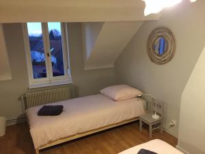 a small bed in a room with a window at L'Autruche Verte in Arleux-en-Gohelle