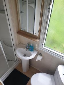 a small bathroom with a sink and a toilet at Seaview caravans in Aberystwyth