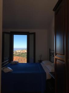 a bedroom with a bed and a window with a view at Hotel Bed Sandalia in Badesi