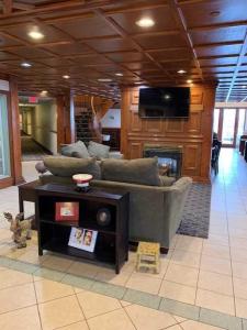 ein Wohnzimmer mit einem Sofa und einem Kamin in der Unterkunft Host Inn an All Suites Hotel in Wilkes-Barre