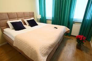 1 cama grande en un dormitorio con cortinas verdes en Apartamenty Chwytowo 14, en Bydgoszcz