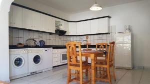 a kitchen with a table and chairs and a refrigerator at Villa de Cactualdea in La Aldea de San Nicolas