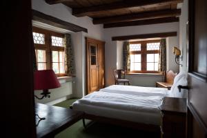 Schlafzimmer mit einem Bett, einem Schreibtisch und Fenstern in der Unterkunft Flyhof in Weesen