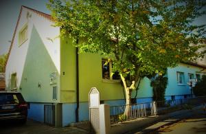 a green and white building with a tree in front of it at Zimmer am Museum in Speyer