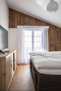 a bedroom with a bed and a large window at Chalet Josianne in Saas-Fee