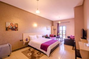 Habitación de hotel con cama y TV en Hotel INOU, en Agadir
