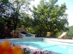 a swimming pool with two lounge chairs and a swimming pool at La Drugère - Gîtes et Roulottes in Nyons